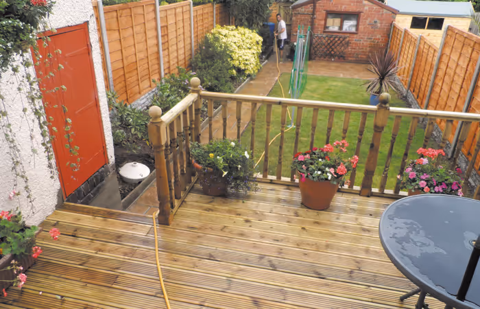 Raised timber deck with railings and planting