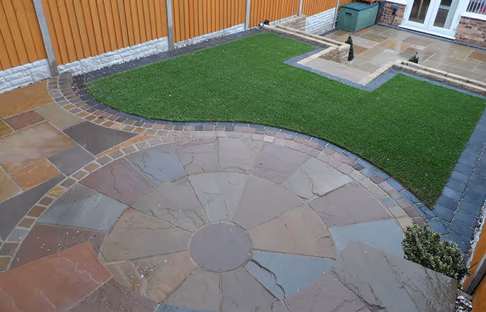 Circular sandstone patio feature with artificial lawn